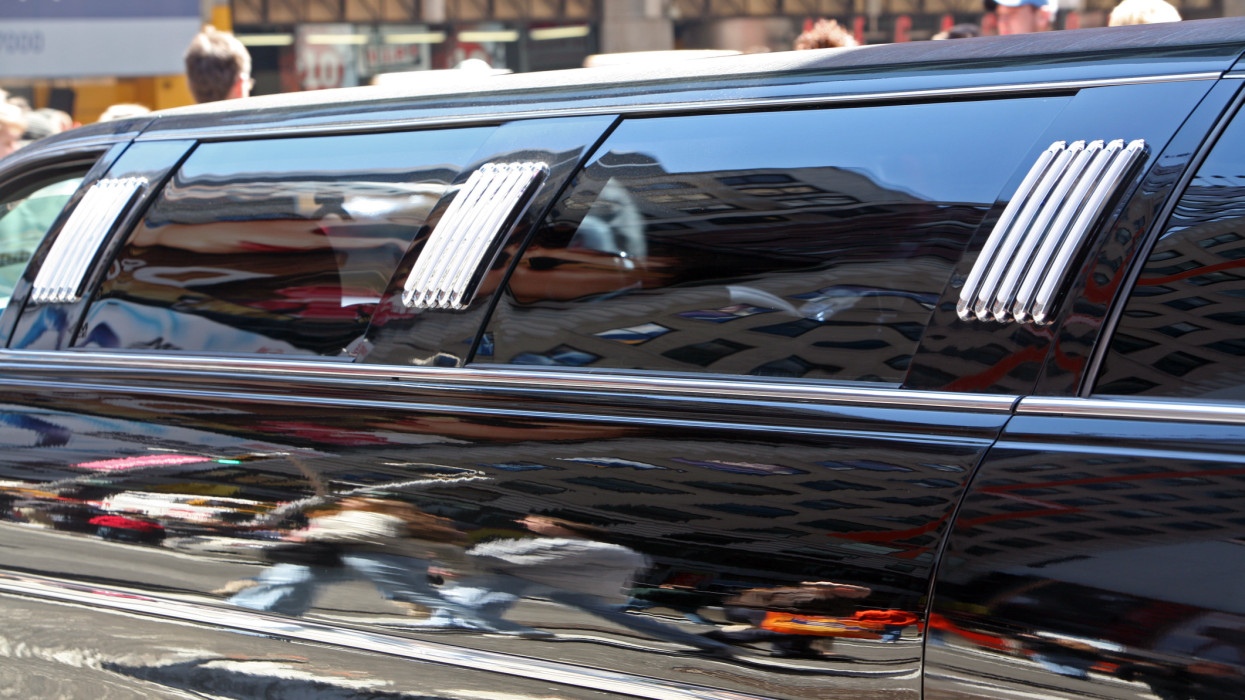 city reflections on side of stretch limousine in Times Square, New York City, NY, USA.