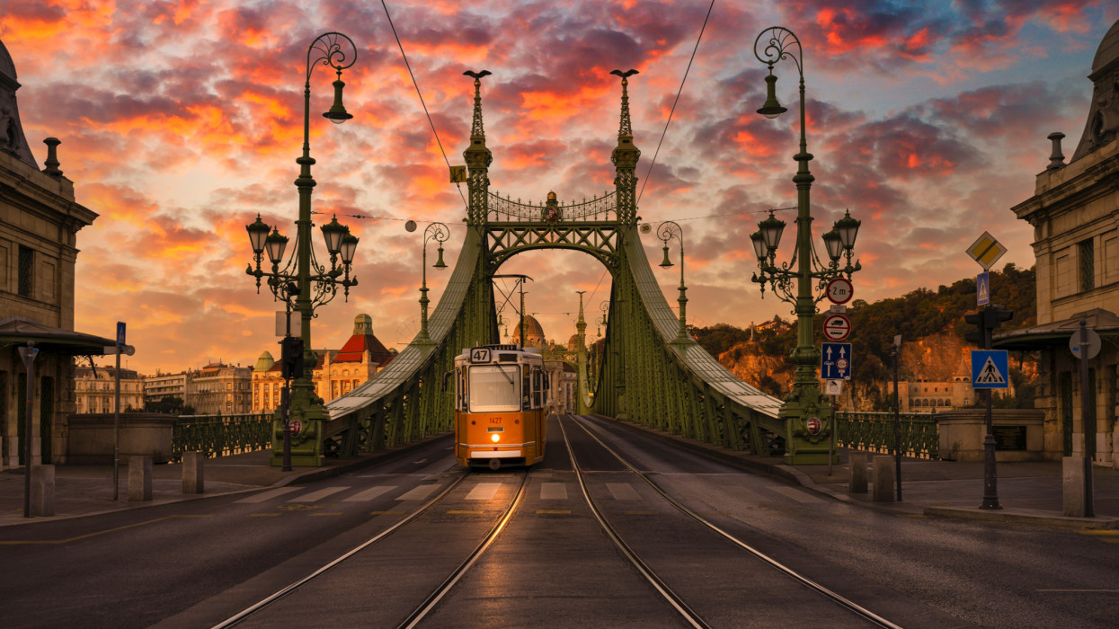 Yellow tram just crossed the Danube river over the Liberty bridge at Beautiful Sunrise in Budapest