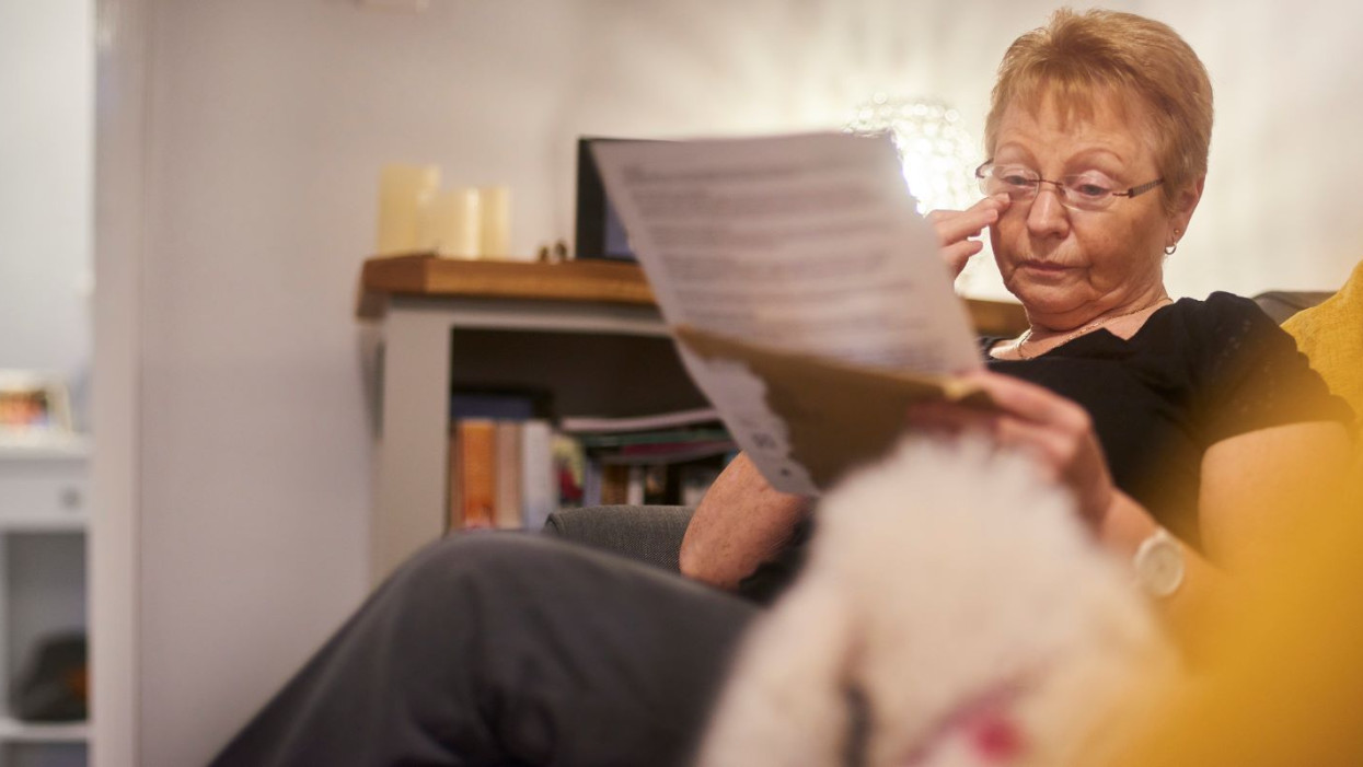 An upset senior woman reading through a letter