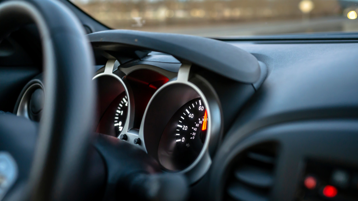 The speedometer of a crossover car with a gray interior with a luminous dial located on the information control panel shows the actual speed of the car on the road, flashing behind the windshield