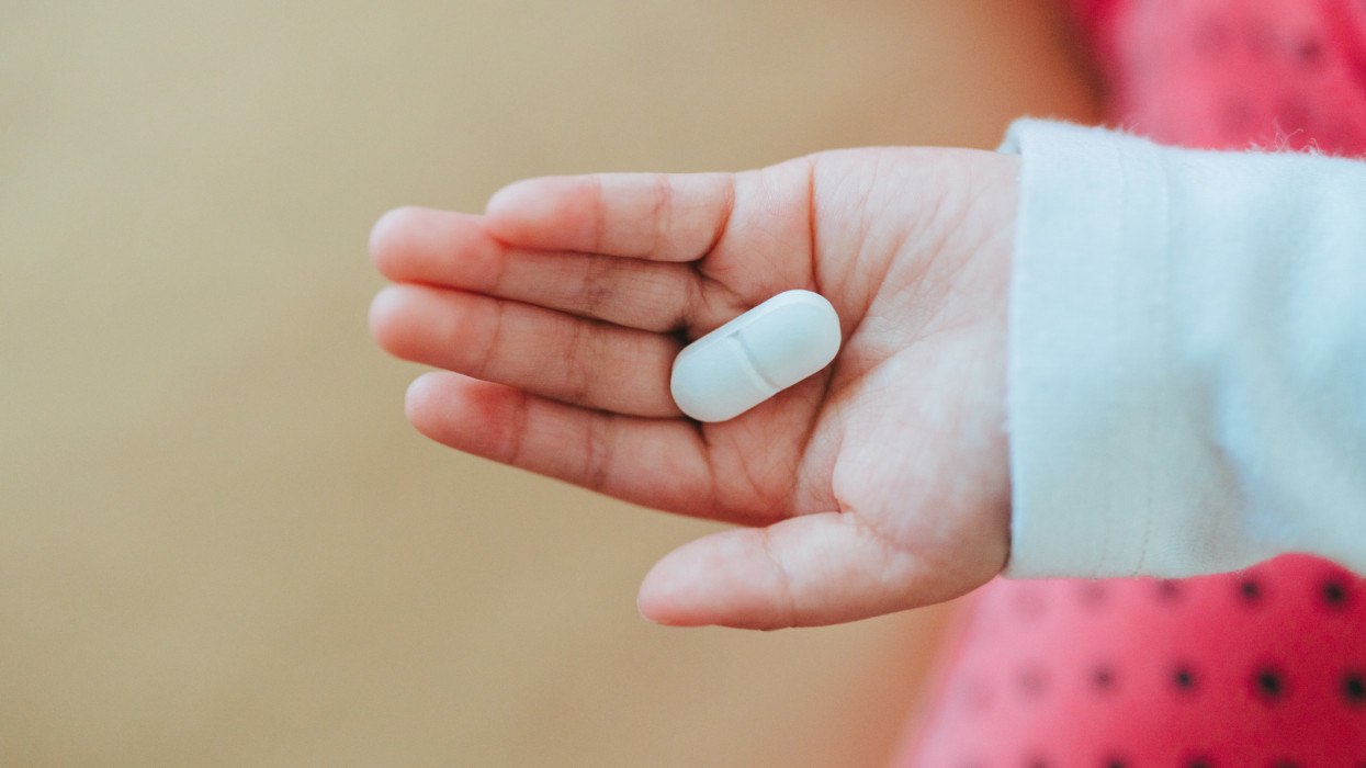 medical tablet pill on hand of a baby