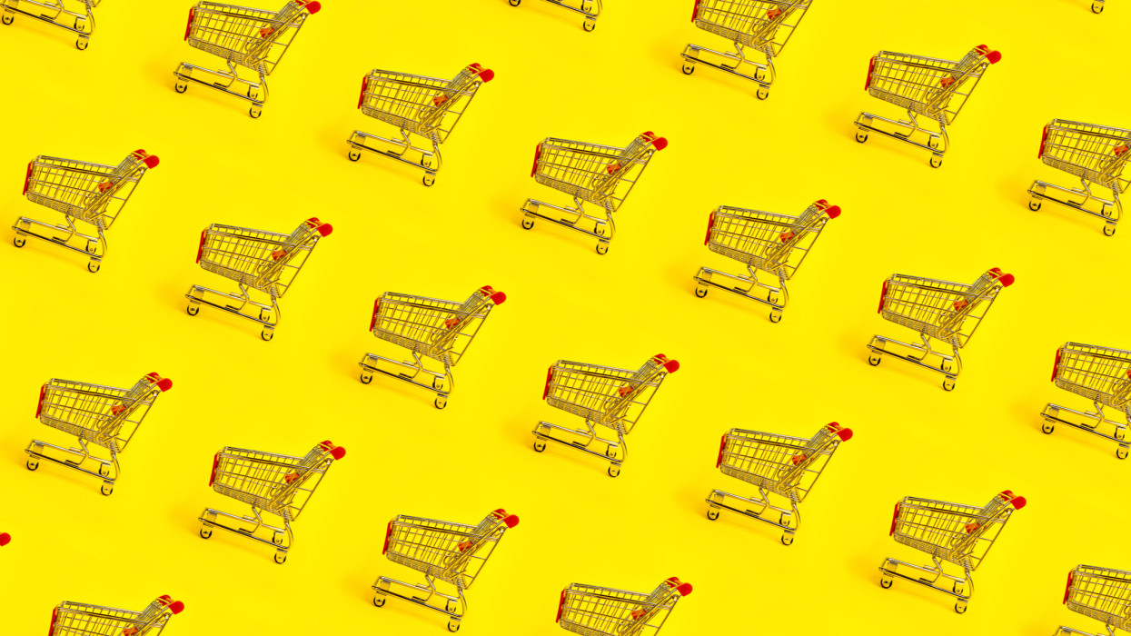 Shopping trolley pattern on yellow background. Shopping Cart as sign of Black Friday.