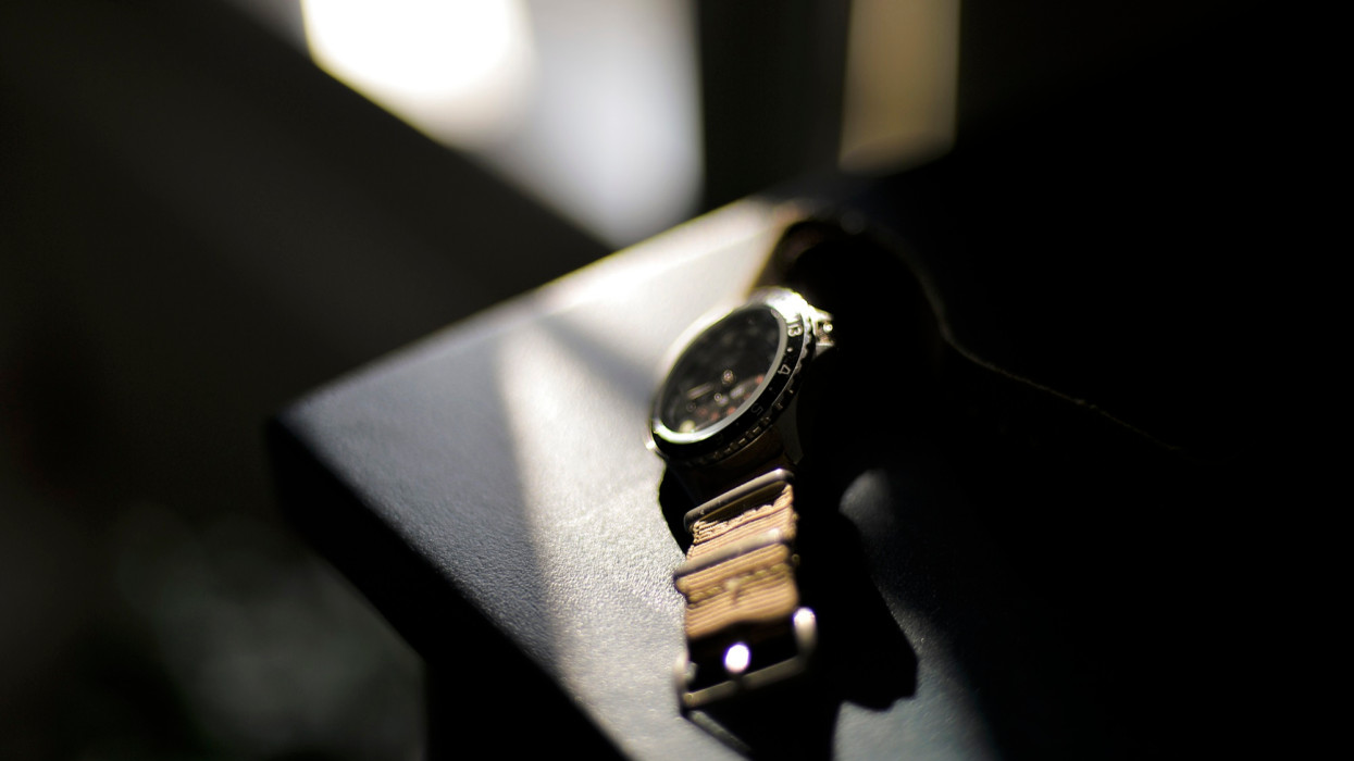 Vintage wristwatch on bedside table in strong sunlight