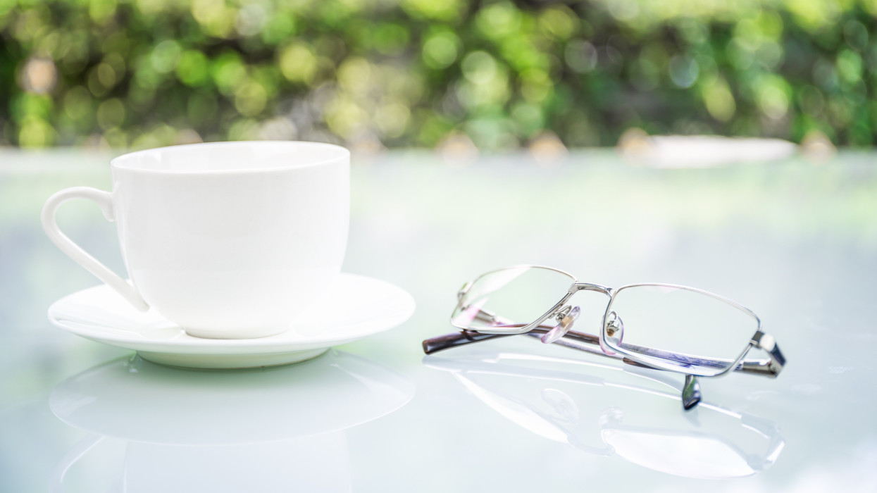 Close up Eyeglasses on table at home with coffee cup