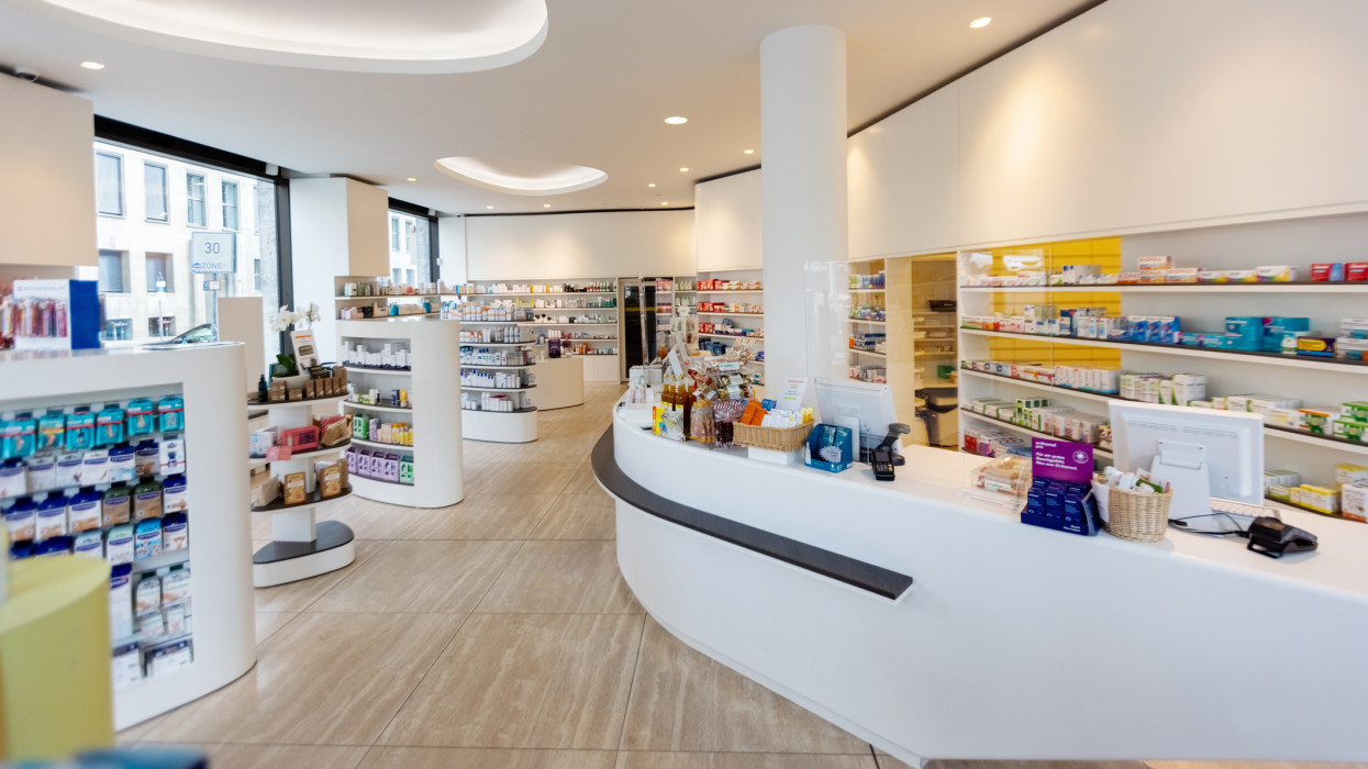 Interior of a modern medical store. Shelves and racks stocked with various medicines in a chemist shop with no people.