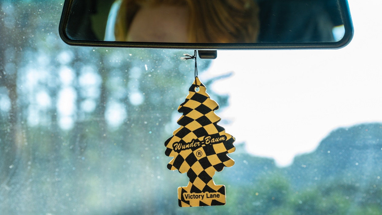 Lindesnes, Norway - June 27 2023: Checkered Wunderbaum car perfume tree hanging from a rear mirror in a car.