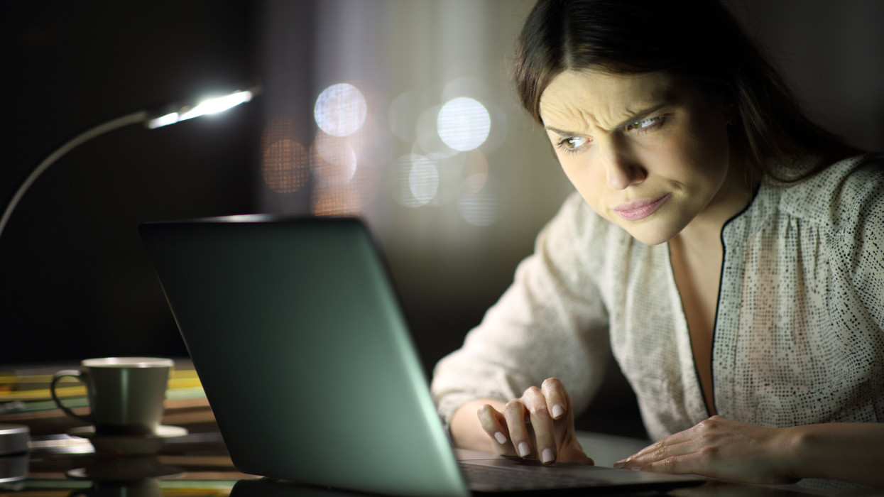 Suspicious woman checking laptop content in the night