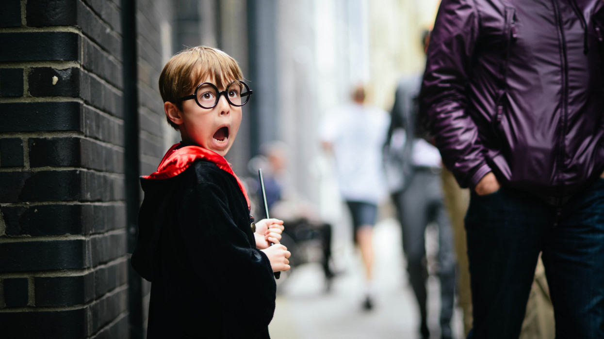 Boy, pretending to be Harry Potter. He is carrying a wand and has his mouth wide open as he pretends to see a Dementor.