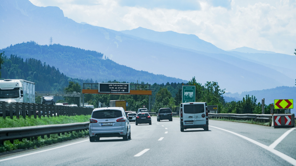 A view of the traffic and surroundings on the European route E45 in Austria.European route E45 is among the longest southânorth highways in Europe.The mountains and scenic surrounding settlements are visible in the background.The road traffic is travelling on the right hand side.
