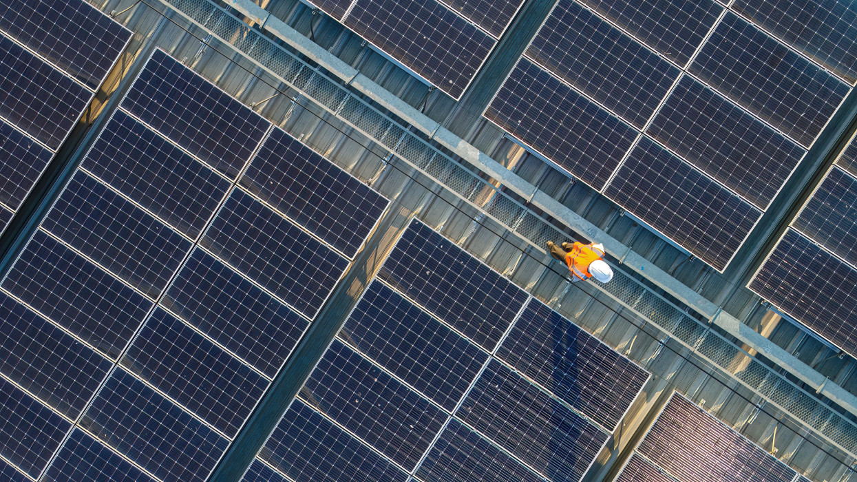 Aerial view of Engineers working at solar panels roof