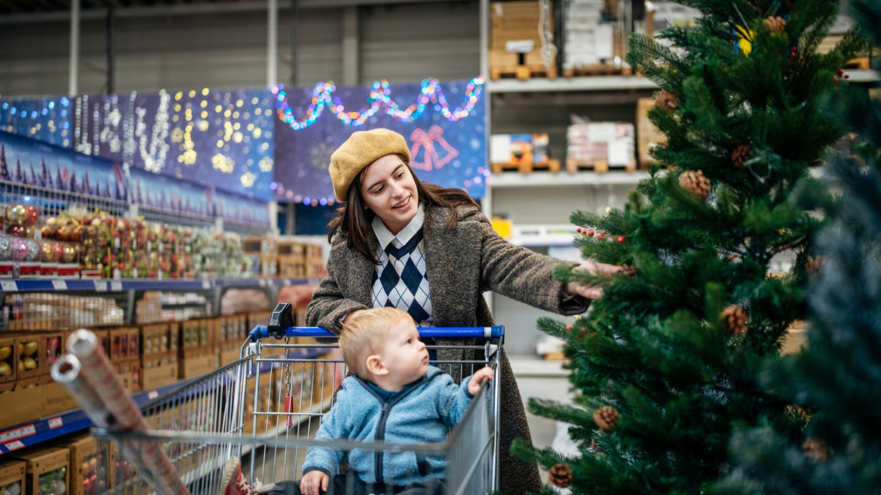 Young mom and her son shopping for Christmas decoration.