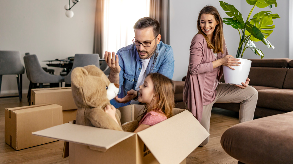 Happy family with child moving with boxes in a new apartment house.Family unpacking boxes in new home.