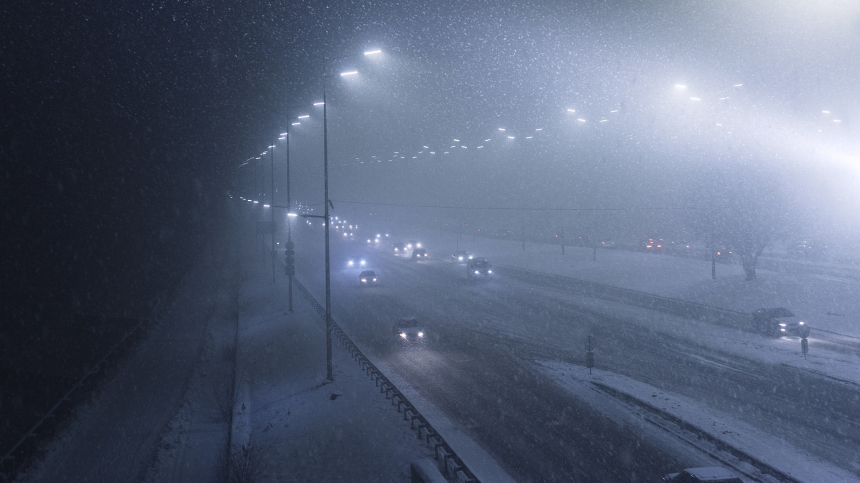 Top view of Heavy snowfall on the motorway at night, difficult weather conditions will create problems with movement in the city during heavy snowfall