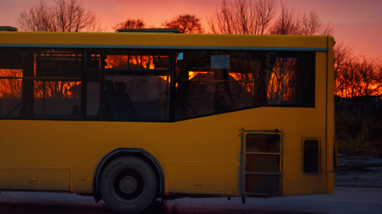 A yellow bus Ikarus at sunset close-up