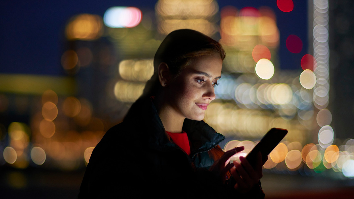 Woman using digital device against a background of modern office buildings