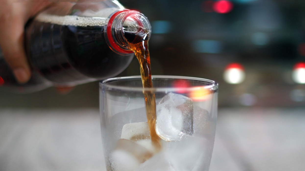 Front view, Pouring cola soda with ice and bubble, cold drink beverage on night background