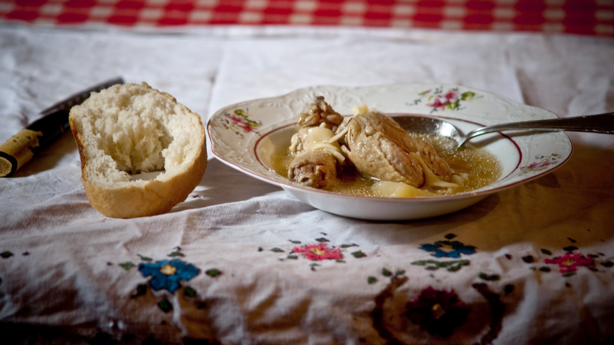 Chicken stew with bread lunch on the table hot and paper.Often meal in the Pannonian Plain in Hungary, Serbia - Vojvodina and Romania wich cook in less affluent families as a daily meal. It is usually a good angry and although very inexpensive tasty meal.