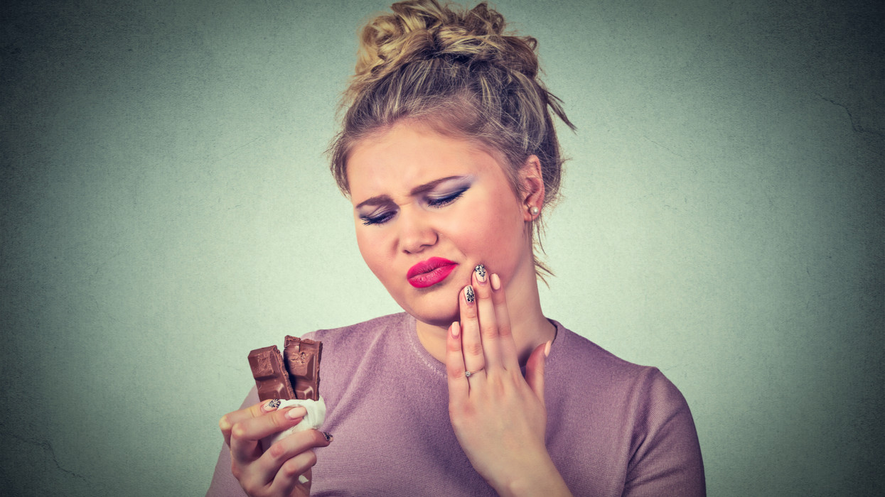 chocolate lover young woman with toothache sensitive teeth