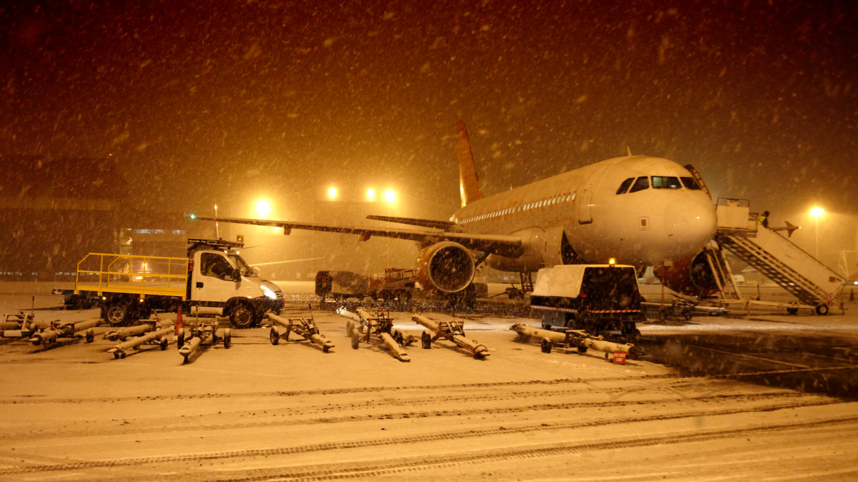 An aircraft or airplane in heavy winter snow at an airport