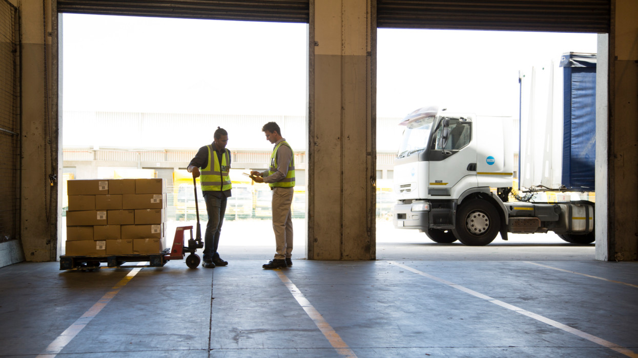 Workers moving stock and loading a lorry in a food distribution warehouse