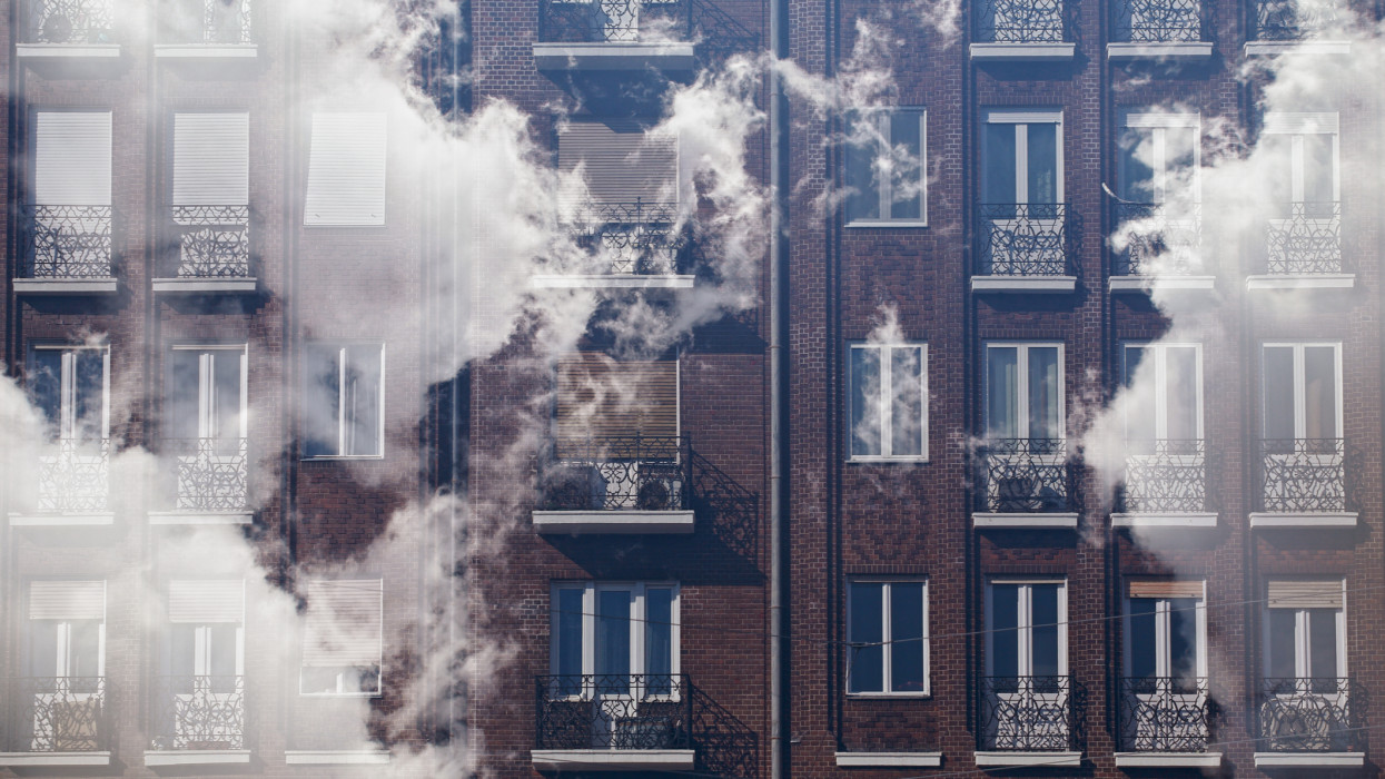 Illustration of global warming, smog city, greenhouse effect: house with clouds made by multiple exposure at Budapest, capital city of Hungary; color photo.