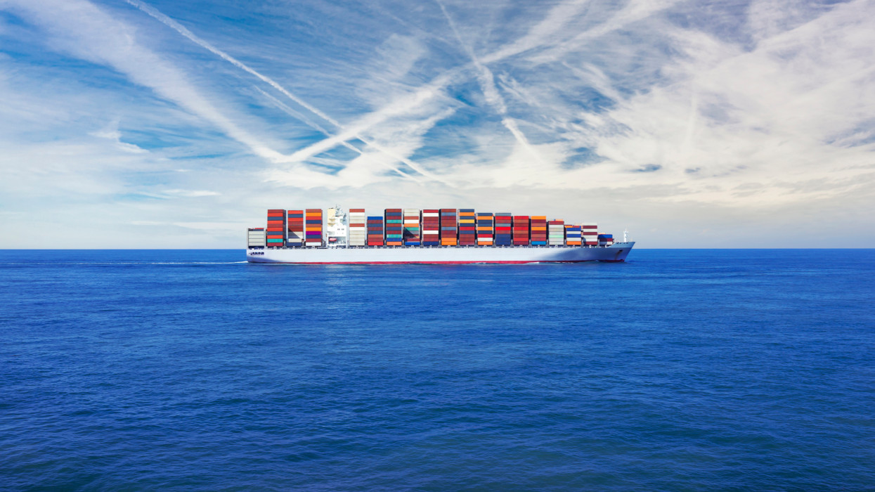 Freight transportation - A large cargo container ship transporting hundreds of multi coloured containers across the sea