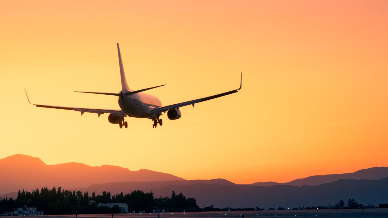 Amidst a breathtaking sunset, an airplane lands gracefully, offering a sense of adventure and escape. With majestic mountains as a backdrop, the scene embodies the beauty and tranquility of a vacation journey.