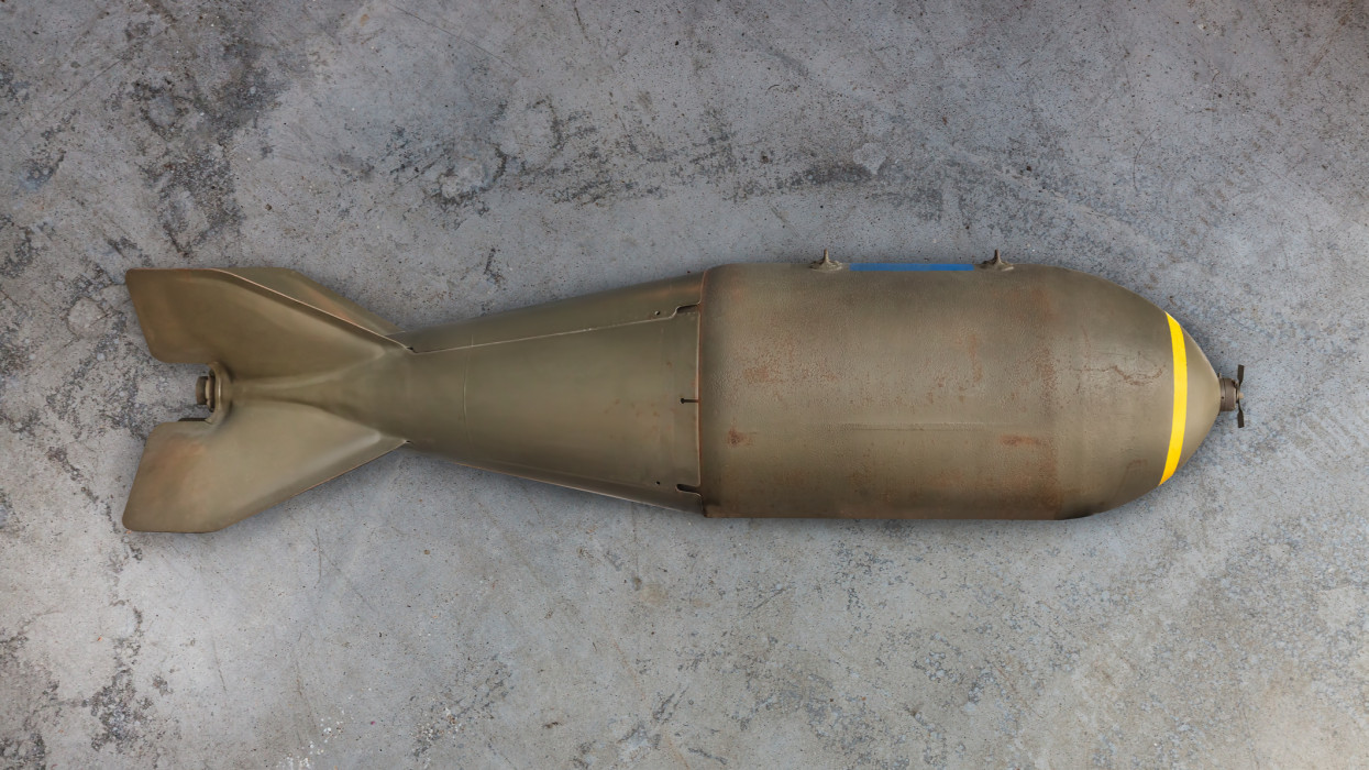 Ancient military missile bomb in front of an eroded grey background