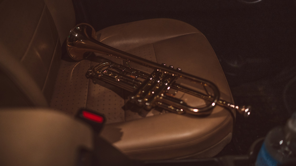 Close-up of trumpet on the seat in a car.