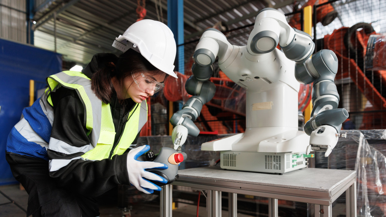 Female engineer control robot in factory