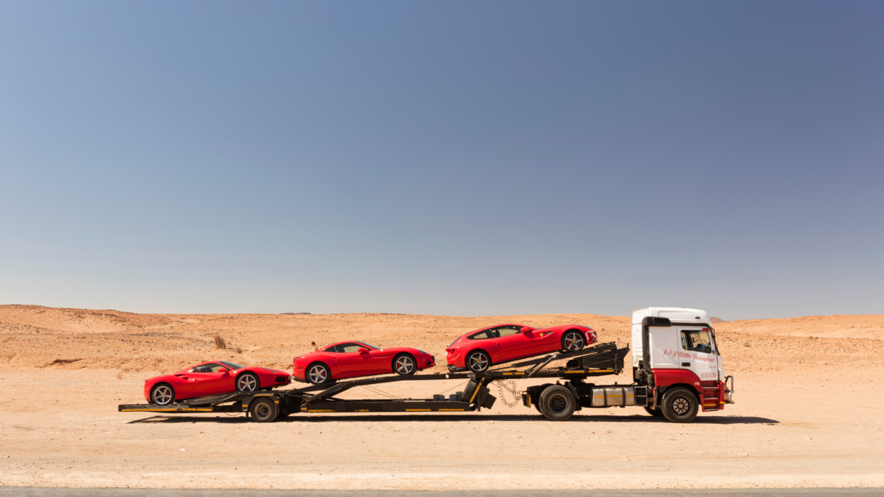 Red sports cars on the back of a car carrier lorry near the border in Namibia, Southern Africa