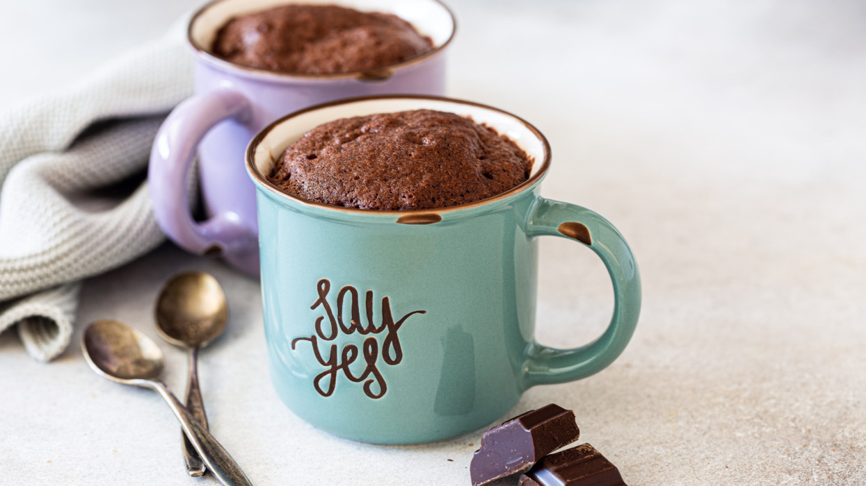 Chocolate Mug Cakes in vintage colorful cups on gray background. Fast cooking in the microwave. Copy space.