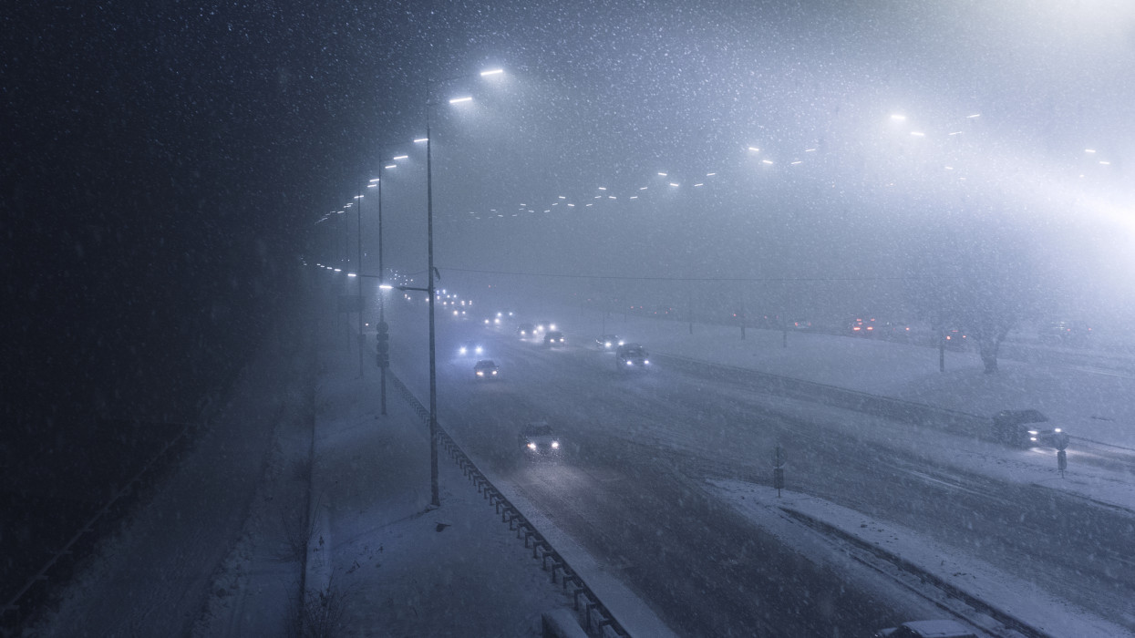 Top view of Heavy snowfall on the motorway at night, difficult weather conditions will create problems with movement in the city during heavy snowfall
