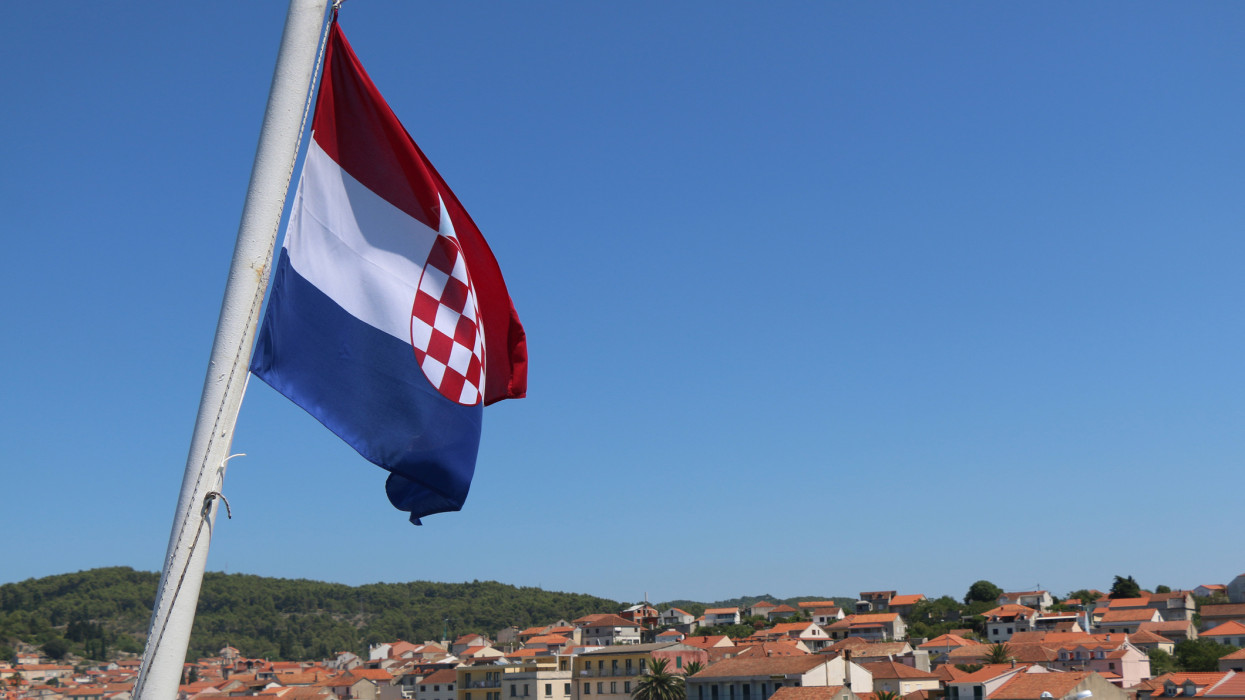 Croatian flag in the wind, above town Vela Luka, on island Korcula, Croatia. Selective focus.