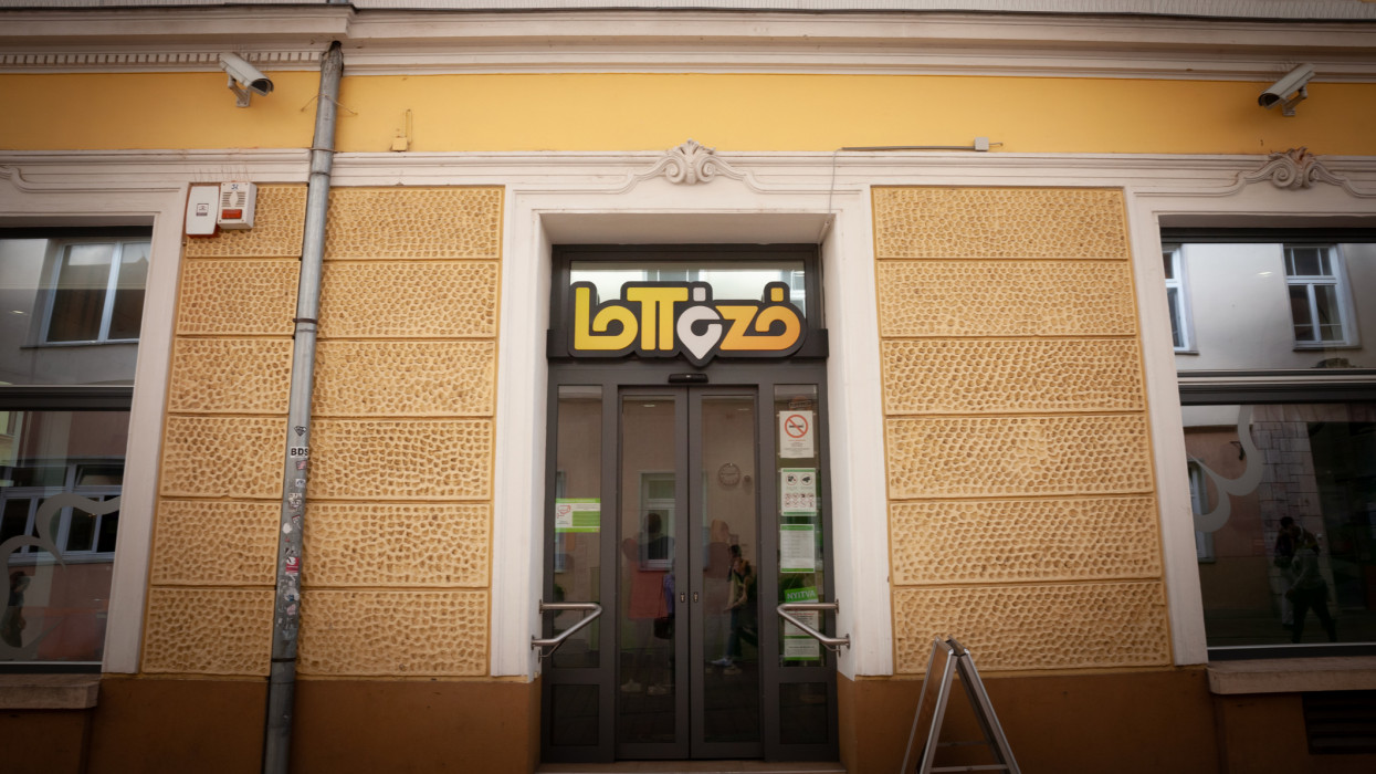 Picture of a sign with the logo of Lottozo on their local office for Pecs, Hungary. Lottozo is the state owned national lottery of Hungary.