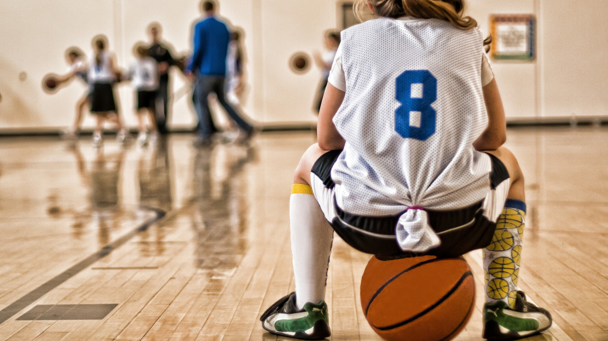 Girl wearing basketball jersey.
