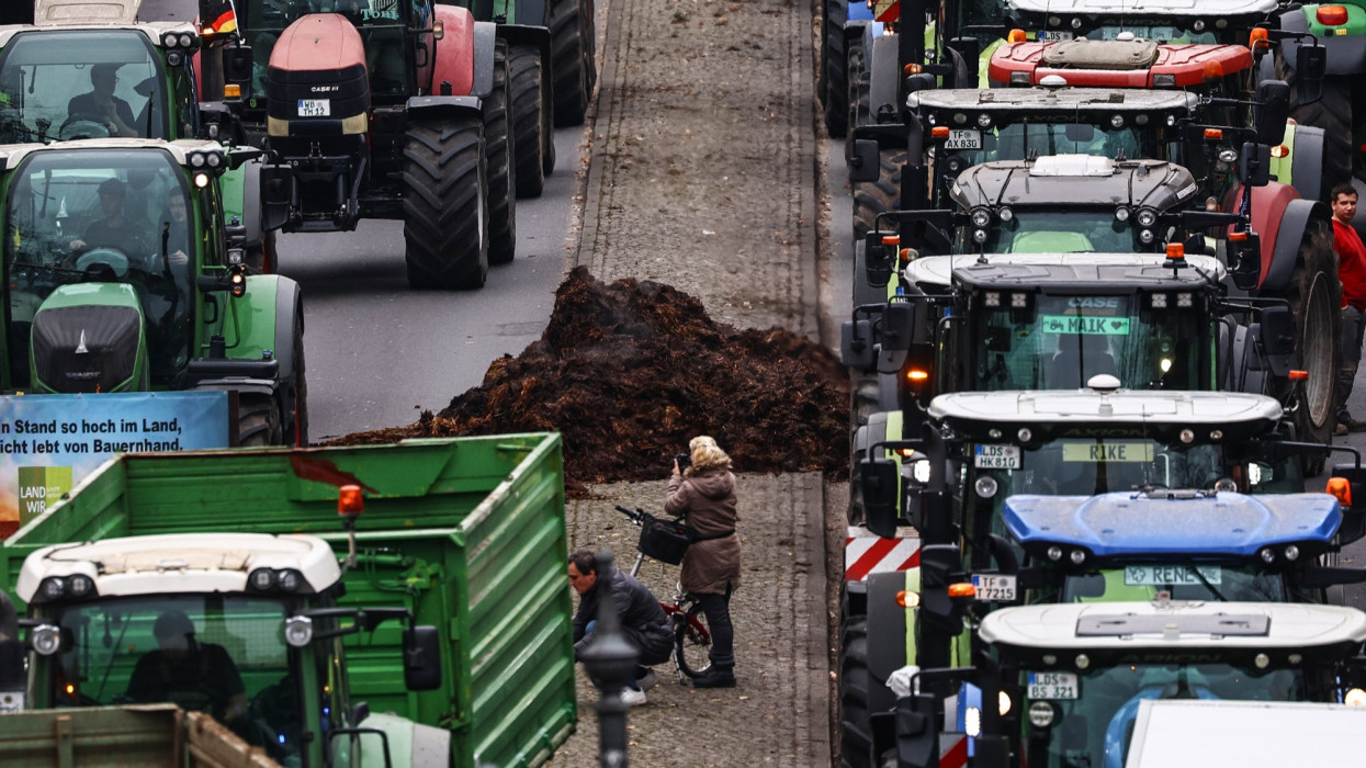 Berlin, 2023. december 18.Tüntetõ gazdálkodók traktorokkal és egy halom trágyával a berlini Június 17. úton 2023. december 18-án. A gazdák a jármûveikhez és munkagépeikhez szükséges gázolaj adókedvezményének eltörlése miatt tiltakoznak, amivel a kormány a költségvetésben keletkezett hiány egy részét igyekszik pótolni.MTI/EPA/Filip Singer
