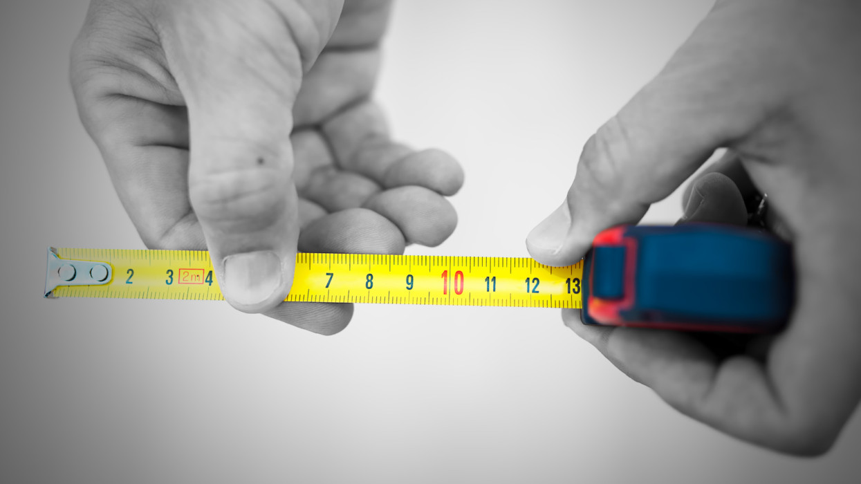 Close up hand holding tape measure.