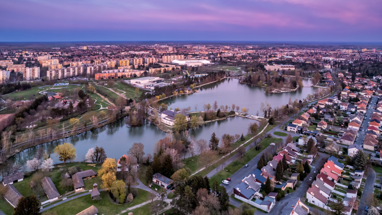 Aerial purple twilight above the boating lake of Szombathely, Hungary with the citys skyline in the background.