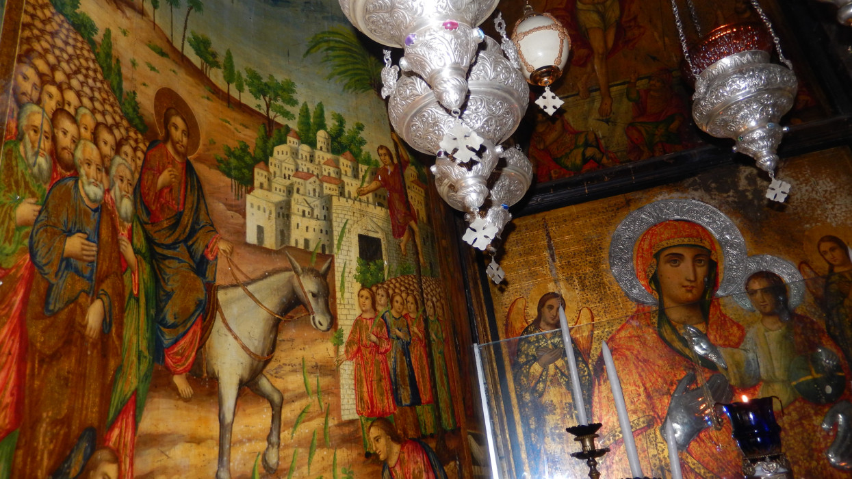 Jerusalem, Israel - October 11, 2015: Biblical scene of Christ entering Jerusalem riding a donkey and scene of the Virgin and Child painted on the walls of the tiny Coptic chapel in the Church of the Holy Sepulchre in Old City of Jerusalem, Israel.