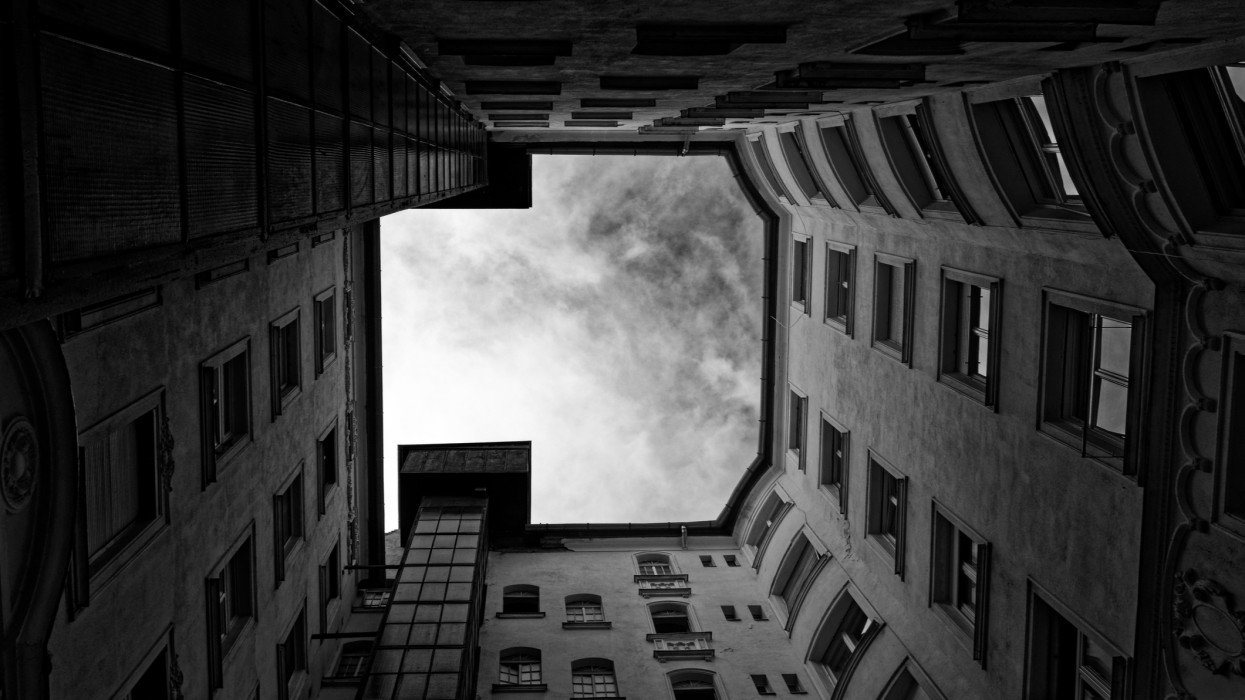 Black and white low angle view in the middle of an tenement house top up the sky