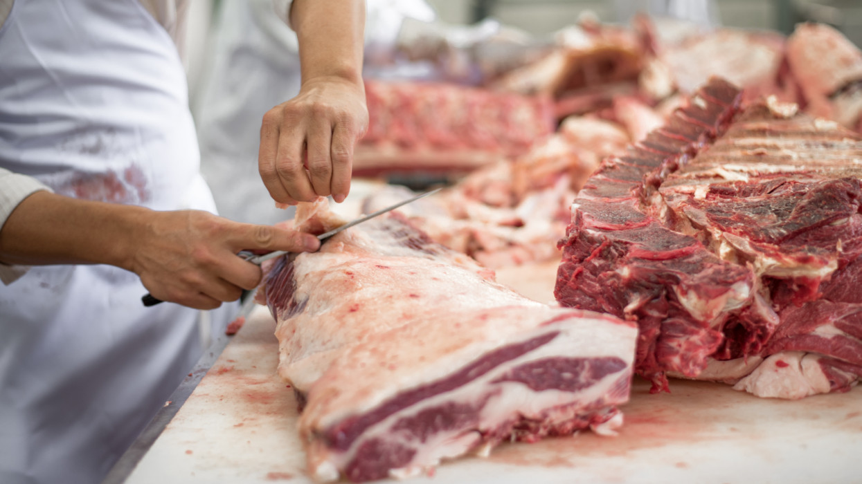 Butcher cutting meat food industry concept