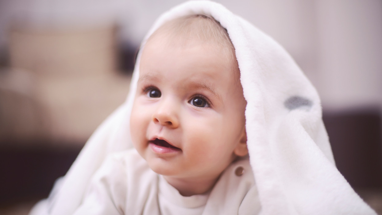 Smiling baby after shower with towel on head