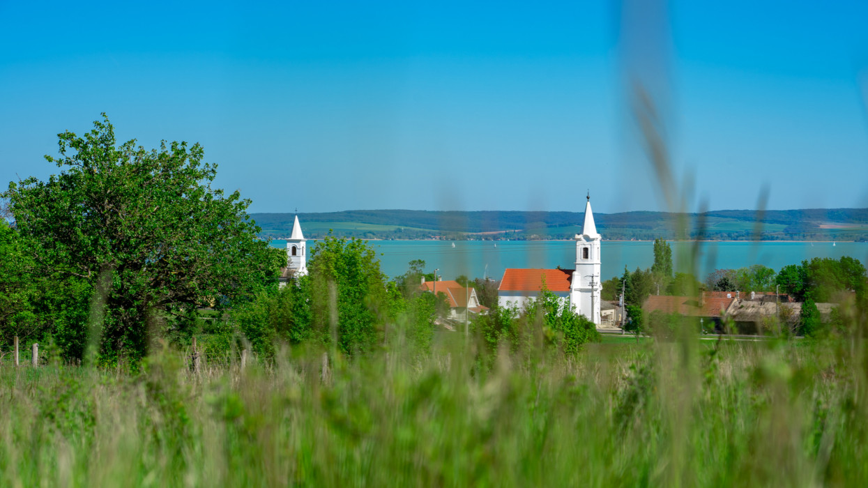 2 beautiful white churches of Balatonakali with the view of lake Balaton .