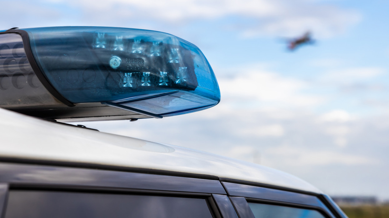 Police light on a car of the German police with passenger aircraft in the sky in the background