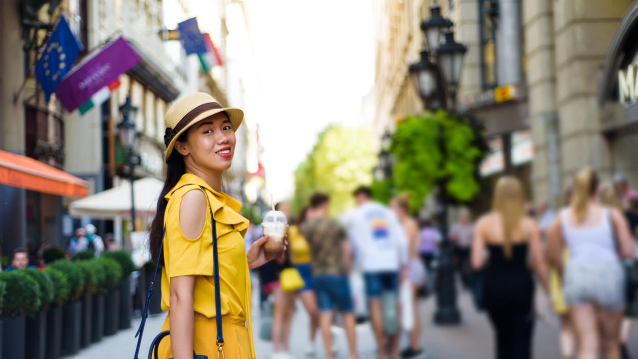 Asian girl on the street with coffee to go