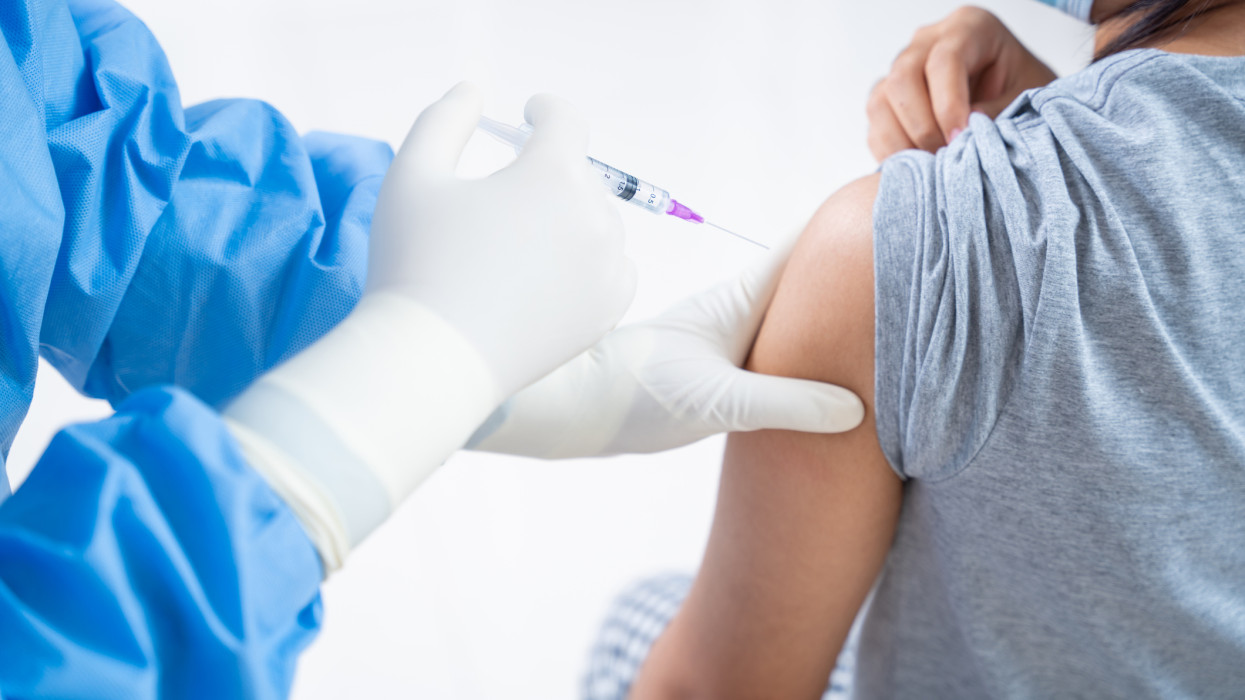 Orvos olt be tizenéves lányokat, influenza oltás injekció a kar, coronavírus, covid-19 vakcina betegség előkészítése az emberi klinikai vizsgálatok vakcinázás lövés