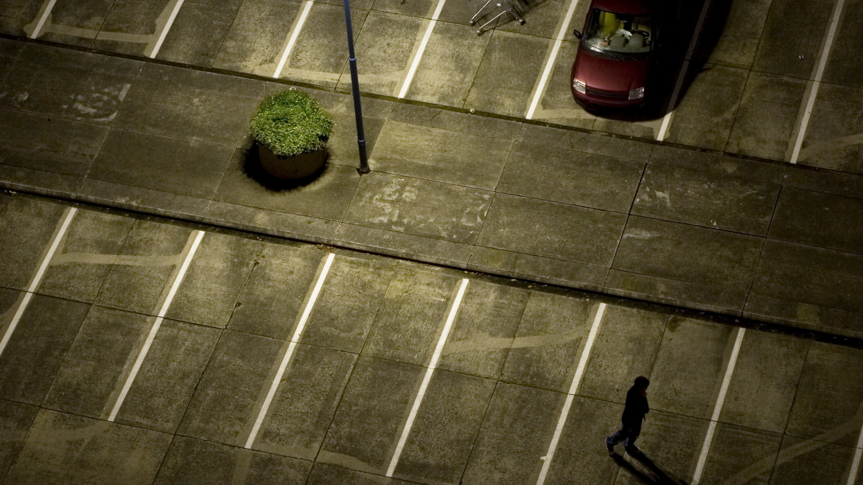 nightshot of a desolate roof parking lot. (note: car has been altered for logo and licence plate)