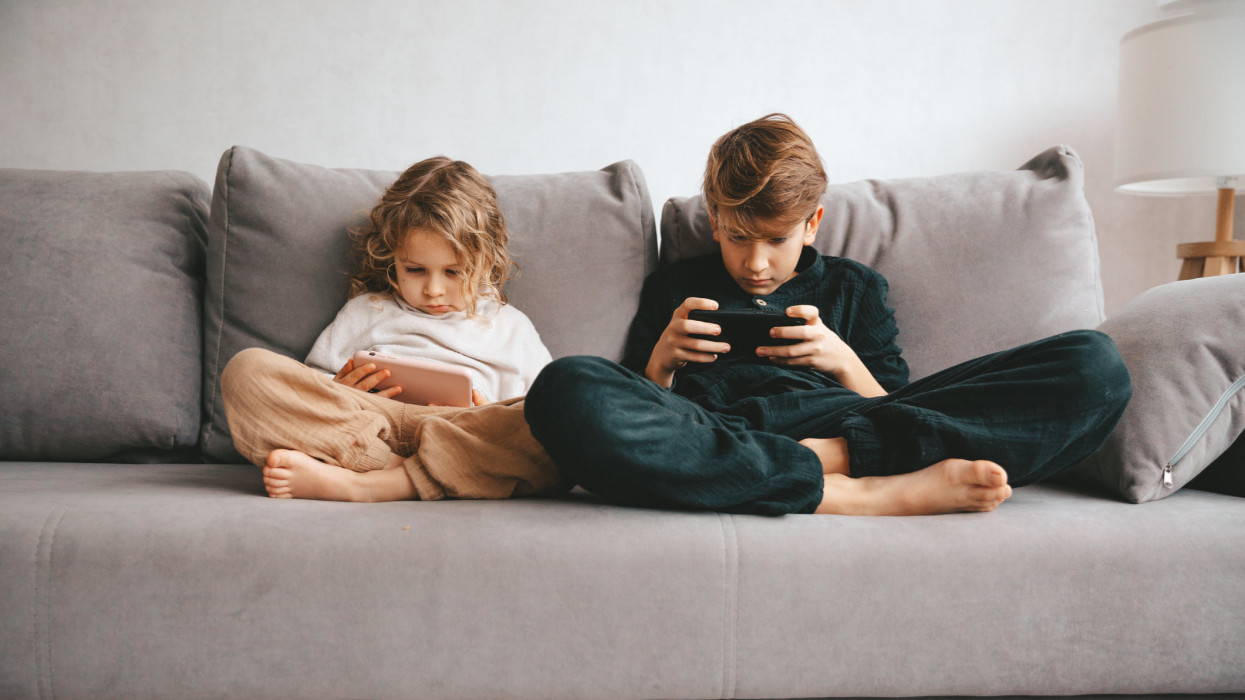 Beautiful little girl and teenager boy with smartphone. Leisure, children, technology and people concept