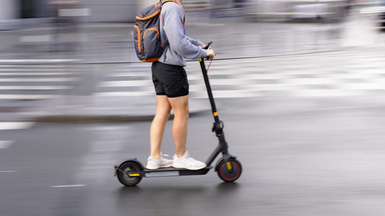 motion blur picture of an unrecognizable person with an electric scooter on a city street